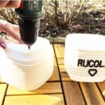 Ik boor drainagegaten in een witte pot voor rucola